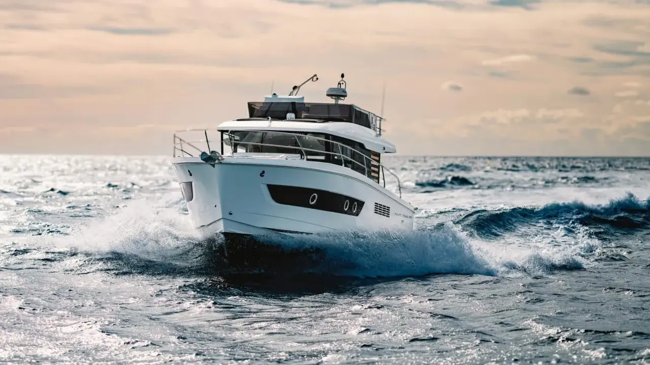 Un bateau blanc fend les vagues, le moteur de 20 cv propulsant l'embarcation à pleine vitesse.