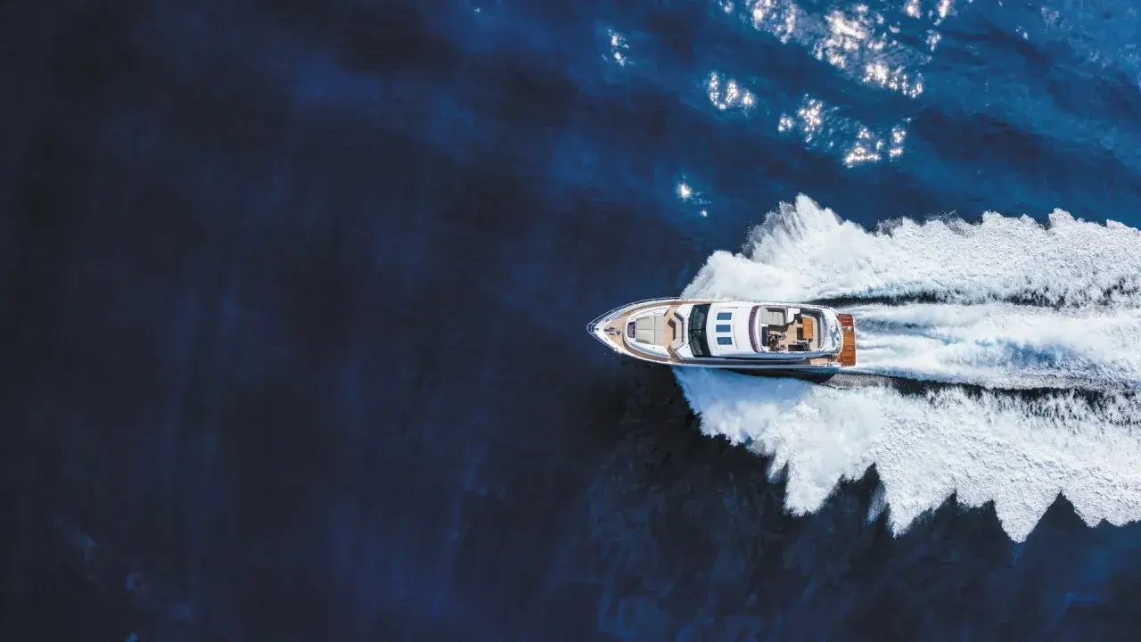 Un bateau hors-bord puissant fend les eaux bleues, laissant une traînée d'écume blanche derrière lui.