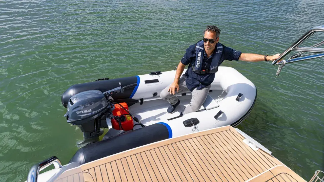 Un homme en gilet de sauvetage dans un semi-rigide, prêt à partir avec le moteur bateau 6cv le plus puissant.