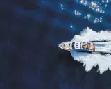 Un bateau hors-bord puissant fend les eaux bleues, laissant une traînée d'écume blanche derrière lui.