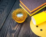Outils de ponçage : brosse métallique, éponges abrasives et papier de verre pour préparer une surface en polyester avant l'application d'époxy.