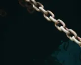 Chaîne rouillée d'une ancre de bateau, plongeant dans l'eau sombre et agitée.
