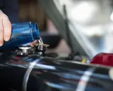 Maintenir le moteur 4 temps en bon état : on verse du liquide de refroidissement bleu dans le réservoir.