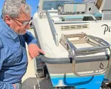 Un homme examine les dégâts sur le gelcoat d'un bateau. C'est quoi le gelcoat ? C'est la couche protectrice extérieure.