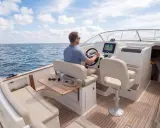 Un homme pilote un bateau sur la mer, le tableau de bord affiche le numéro MMSI.