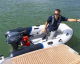 Un homme en gilet de sauvetage dans un semi-rigide, prêt à partir avec le moteur bateau 6cv le plus puissant.