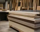 Pile de contreplaqué marine prête à être peinte. Des planches de bois sont empilées dans un atelier.