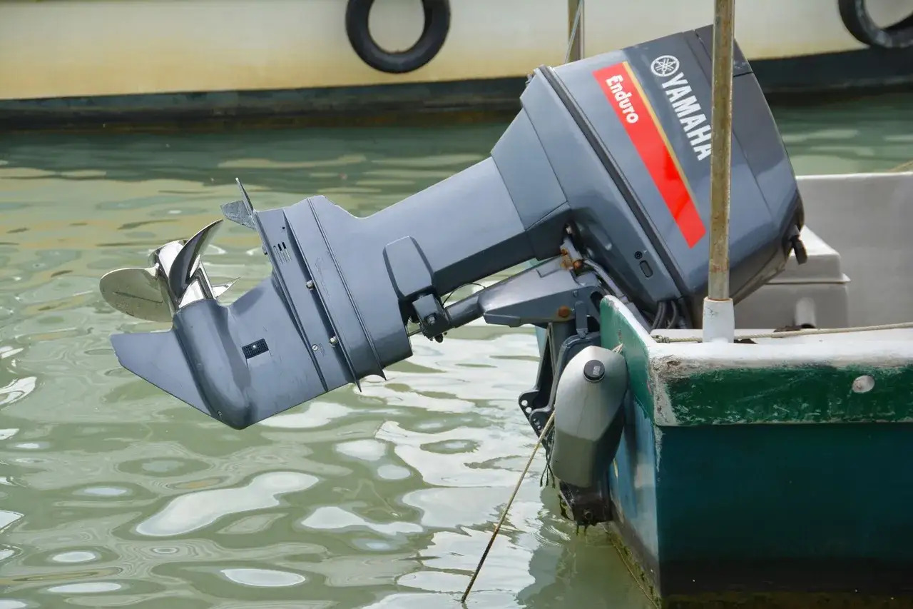 Moteur hors-bord Yamaha Enduro 2 temps, prêt pour son entretien moteur 2 temps bateau. Hélice visible dans l'eau.