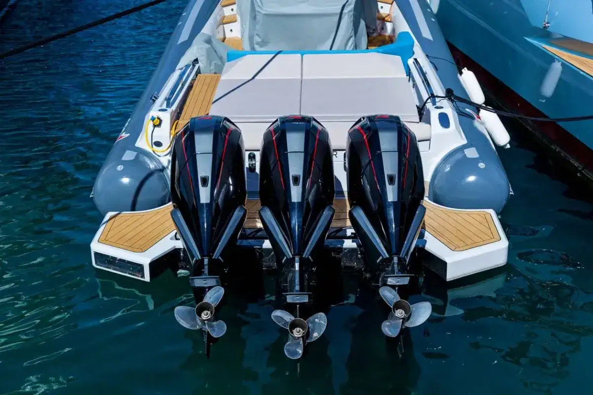 Trois moteurs hors-bord puissants sur un bateau gonflable, prêts à fendre les vagues.