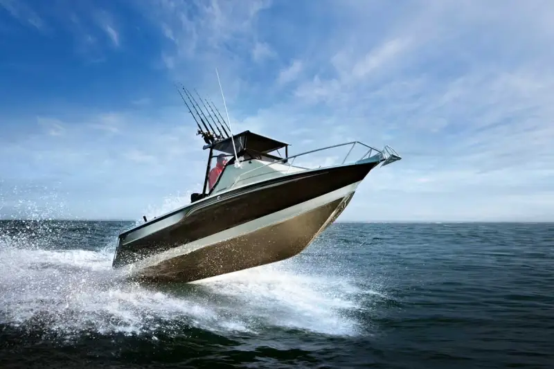Bateau de pêche rapide sur l'eau, créant des éclaboussures. Le moteur du bateau est puissant, optimisant la consommation.